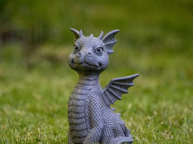 gray dragon figurine on green grass