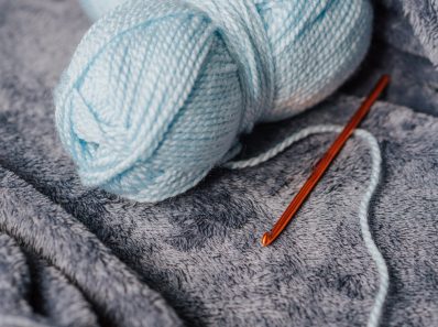 blue yarn and hook on blanket