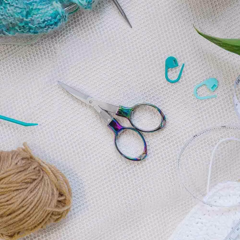 ciseaux pliables dans un atelier avec des marqueurs de maille, des fils