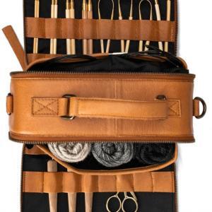 Sac de rangement pour le crochet en cuir whisky ouvert avec des pelotes, des crochets et des aiguilles à tricoter