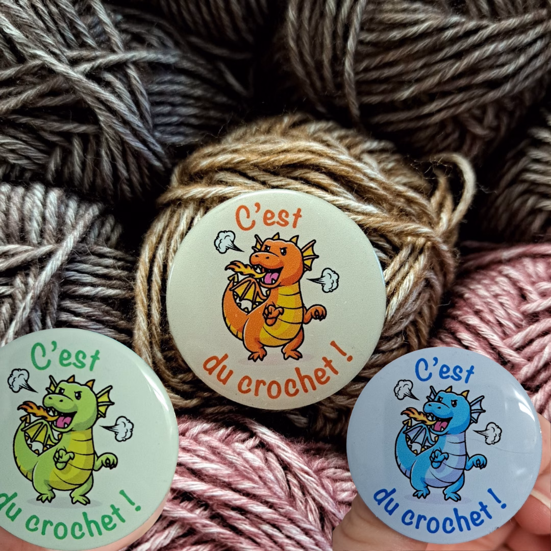 Affiche ta passion avec le pin’s dragon C’est du crochet ! Badge en métal écoresponsable, fabriqué au Royaume-Uni, disponible en vert, bleu et orange.