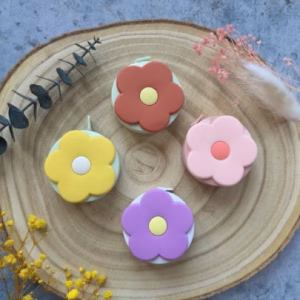 Le mètre ruban Fleur Pop allie mignonnerie et précision : rétractable, double graduation cm/pouces, 4 coloris pop. L'accessoire parfait pour tes projets créatifs !